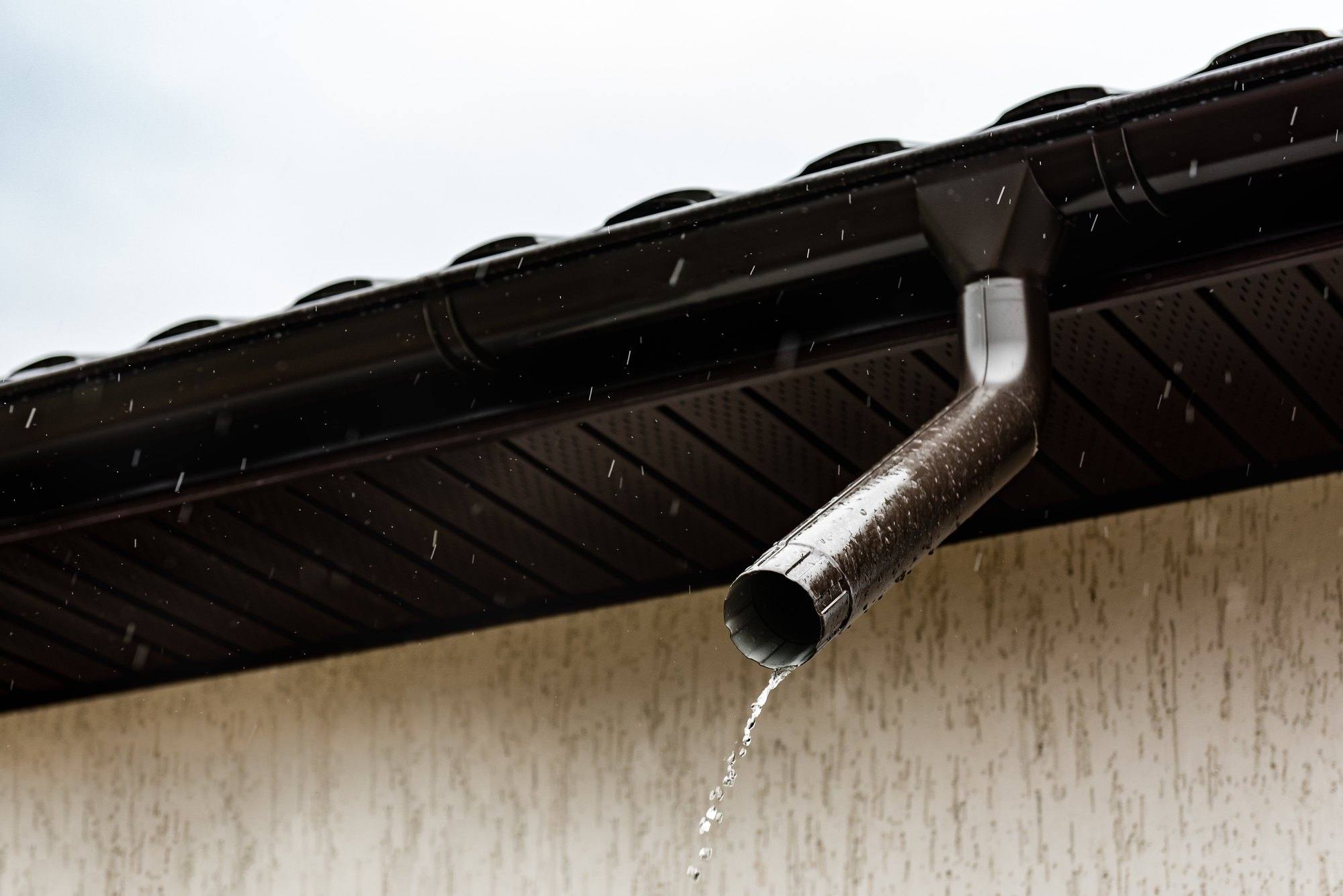 Rainwater pouring out of a metal downspout