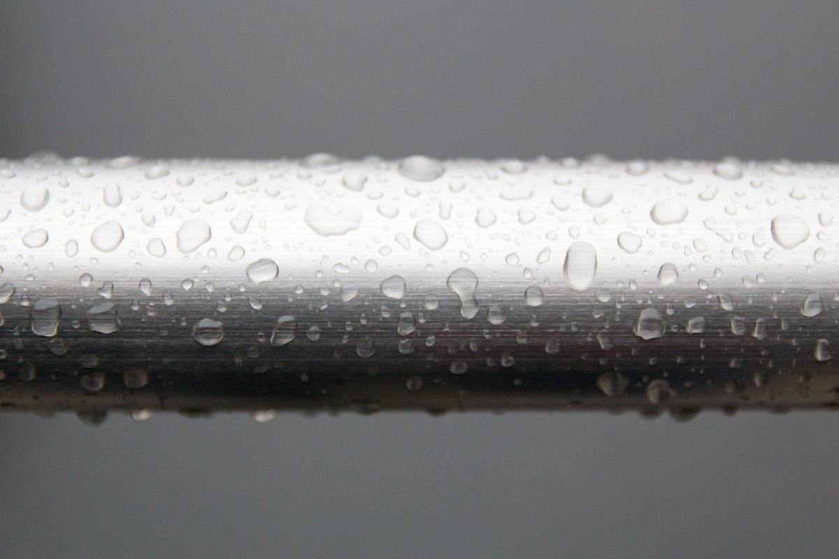 Water droplets condensing on a cold metal pipe